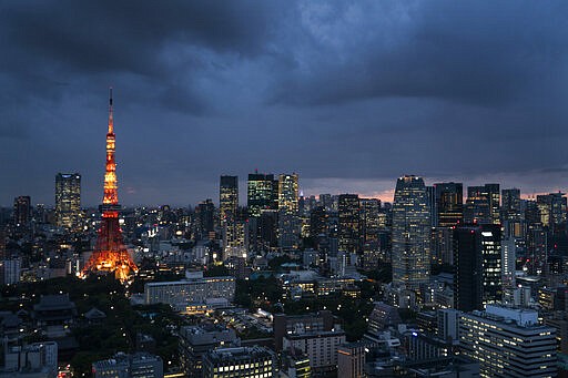 FILE-In this May 29, 2019 file photo the Tokyo Tower is lit up at dusk as rain clouds hover over Tokyo's skyline. Patricia Espinosa, Executive Secretary of the United Nations Framework Convention on Climate Change, on Tuesday chided Japan over its new plan to reduce greenhouse gas emission. Environmental campaigners say Tokyo's new proposal shows no real ambition to increase existing efforts. (AP Photo/Jae C. Hong)