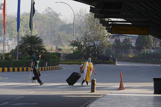 Stranded American citizens arrive to board a Qatar Airways flight at the Tribhuvan International Airport in Kathmandu, Nepal, Tuesday, March 31, 2020. Several American citizens are stranded in Nepal due to the nationwide lockdown enforced in an attempt to stop the coronavirus spread. The new coronavirus causes mild or moderate symptoms for most people, but for some, especially older adults and people with existing health problems, it can cause more severe illness or death. (AP Photo/Niranjan Shrestha)