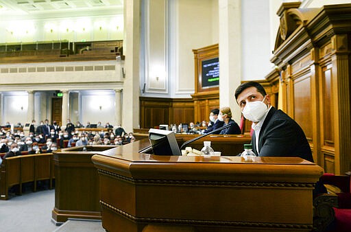 Ukrainian President Volodymyr Zelenskiy wearing a face mask to protect against coronavirus looks on during an extraordinary parliamentary session in Kyiv, Ukraine, Monday, March 30, 2020. Ukraine has been under quarantine since March 12. The new coronavirus causes mild or moderate symptoms for most people, but for some, especially older adults and people with existing health problems, it can cause more severe illness or death. (AP Photo)