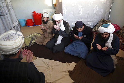 FILE - In this Dec. 14, 2019 file photo, jailed Taliban pray inside the Pul-e-Charkhi Jail, in Kabul, Afghanistan. Afghanistan&#146;s largest prison, Pul-e-Charkhi, was built in the 1970s to house 5,000 prisoners but now holds 10,500. In some cells in Afghanistan, Iran, Egypt, Syria and other countries in the Middle East, prisoners are crammed in by the dozens, with little access to hygiene or medical care. So if one infection gets in, the novel coronavirus could run rampant. (AP Photo/Rahmat Gul, File)