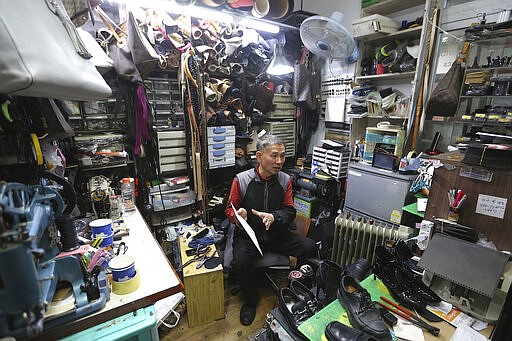 In this March 25, 2020 photo, South Korean shoe repairman Kim Byung-rok speaks during an interview at his shop in Seoul, South Korea.  Kim is in news after he revealed plans to donate his property to help support people facing economic difficulties amid the coronavirus outbreak. Kim says he wants to donate parts of his land on a small mountain near the border with North Korea that he bought in 2014. (AP Photo/Ahn Young-joon)