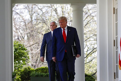 President Donald Trump and Vice President Mike Pence arrive to speak about the coronavirus in the Rose Garden of the White House, Monday, March 30, 2020, in Washington. (AP Photo/Alex Brandon)