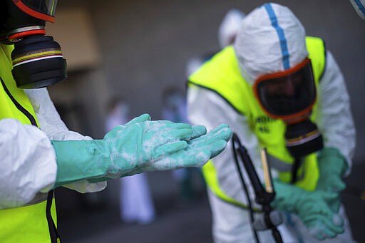 Spanish Royal Guard soldiers during disinfection work at a hospital to prevent the spread of the new coronavirus in Madrid, Spain, Sunday, March 29, 2020. Spain and Italy demanded more European help as they fight still-surging coronavirus infections amid the continent's worst crisis since World War II. The new coronavirus causes mild or moderate symptoms for most people, but for some, especially older adults and people with existing health problems, it can cause more severe illness or death. (AP Photo/Bernat Armangue)