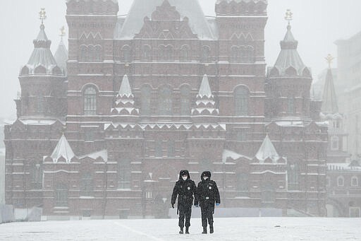 Police officers walk across an empty Red Square in Moscow, Russia, Tuesday, March 31, 2020. The Russian capital has woken up to a lockdown obliging most people in the city of 13 million to stay home. The government ordered other regions of the vast country to quickly prepare for the same as Moscow, to stem the spread of the new coronavirus. The new coronavirus causes mild or moderate symptoms for most people, but for some, especially older adults and people with existing health problems, it can cause more severe illness or death. (AP Photo/Pavel Golovkin)