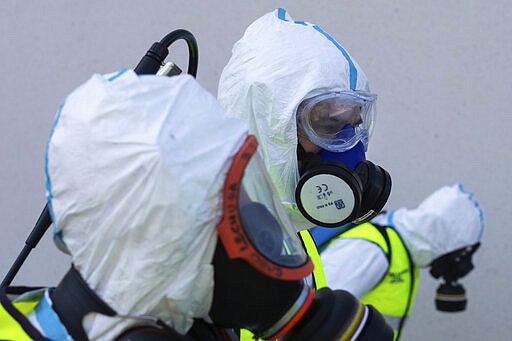 Spanish Royal guard soldiers disinfect a hospital to prevent the spread of the new coronavirus in Madrid, Spain, Sunday, March 29, 2020. Spain and Italy demanded more European help as they fight still-surging coronavirus infections amid the continent's worst crisis since World War II. The new coronavirus causes mild or moderate symptoms for most people, but for some, especially older adults and people with existing health problems, it can cause more severe illness or death. (AP Photo/Bernat Armangue)