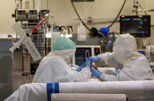 In this photo taken on Friday, March 27, 2020, healthcare workers assist a patience at one of the intensive care units (ICU) at German Trias i Pujol hospital in Badalona, in the Barcelona province, Spain. The new coronavirus causes mild or moderate symptoms for most people, but for some, especially older adults and people with existing health problems, it can cause more severe illness or death. (AP Photo/Anna Surinyach)