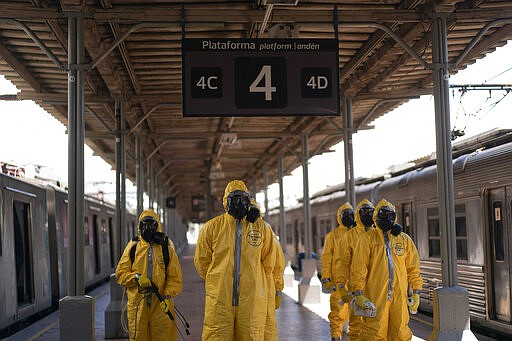 Soldiers stand in formation before disinfecting wagons for the new coronavirus at the central train station in Rio de Janeiro, Brazil, where trains connect cities within the state, Thursday, March 26, 2020. COVID-19 causes mild or moderate symptoms for most people, but for some, especially older adults and people with existing health problems, it can cause more severe illness or death. (AP Photo/Leo Correa)
