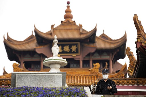 A resident looks out near the Yellow Crane Tower in Wuhan in central China's Wuhan province on Wednesday, April 1, 2020. Skepticism about China&#146;s reported coronavirus cases and deaths has swirled throughout the crisis, fueled by official efforts to quash bad news in the early days and a general distrust of the government. In any country, getting a complete picture of the infections amid the fog of war is virtually impossible. (AP Photo/Ng Han Guan)