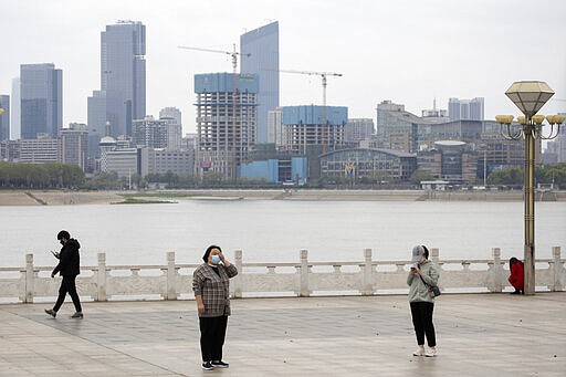Residents observe social distancing at a park along the Yangtze River in Wuhan in central China's Wuhan province on Wednesday, April 1, 2020. Skepticism about China&#146;s reported coronavirus cases and deaths has swirled throughout the crisis, fueled by official efforts to quash bad news in the early days and a general distrust of the government. In any country, getting a complete picture of the infections amid the fog of war is virtually impossible. (AP Photo/Ng Han Guan)