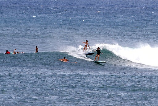 People surf on Oahu's North Shore near Haleiwa, Hawaii, Tuesday, March 31, 2020. Hawaii Gov. David Ige is further tightening travel restrictions to limit the spread of the coronavirus by ordering people moving between islands to adhere to a 14-day self-quarantine. The order takes effect at midnight on Wednesday. It won't apply to essential workers like health care workers traveling to other islands.&#160;The order comes a week after the governor ordered everyone arriving in the state from other states or overseas to follow the same two-week quarantine. He's also ordered everyone in the state to stay at home for the next month.&#160;(AP Photo/Caleb Jones)