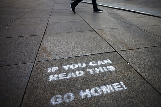 FILE - In this March 30, 2020, file photo, a message demanding the people to go home is sprayed on the ground of Alexanderplatz square in Berlin, Germany. Labs were quick to ramp up their testing capacity and now experts say up to 500,000 tests can be conducted in Germany per week. That quick work, coupled with the country's large number of intensive care unit beds and its early implementation of social distancing measures, could be behind Germany's relatively low death toll.  (AP Photo/Markus Schreiber, File)