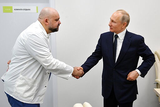 FILE In this file photo taken on Monday, March 23, 2020, Russian President Vladimir Putin, right shakes hands with the hospital's chief Denis Protsenko during his visit to the hospital for coronavirus patients in Kommunarka, outside Moscow, Russia. The chief doctor of Moscow's top hospital for coronavirus patients says he has tested positive for the virus, a statement that comes a week after his encounter with President Vladimir Putin. Putin visited the Kommunarka hospital on March 23. (Alexei Druzhinin, Sputnik, Kremlin Pool Photo via AP, File)