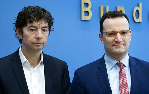 FILE - In this March 9, 2020, file photo, Christian Drosten, left, virologist of the Charite hospital, and German Health Minister Jens Spahn, right, arrive for a press conference on the new coronavirus in Berlin, Germany. &#147;The reason why we in Germany have so few deaths at the moment compared to the number of infected can be largely explained by the fact that we are doing an extremely large number of lab diagnoses,&quot; said Drosten, whose team developed the first test for the new virus. (AP Photo/Michael Sohn, File)