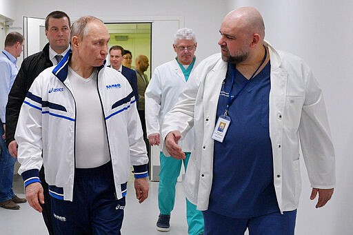 FILE - In this file photo taken on Monday, March 23, 2020, Russian President Vladimir Putin, center, and the hospital's chief Denis Protsenko, right, walk in to the hospital for coronavirus patients in Kommunarka, outside Moscow, Russia. The chief doctor of Moscow's top hospital for coronavirus patients says he has tested positive for the virus, a statement that comes a week after his encounter with President Vladimir Putin. Putin visited the Kommunarka hospital on March 23. (Alexei Druzhinin, Sputnik, Kremlin Pool Photo via AP, File)