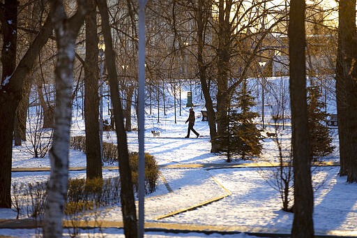 A woman walks her dog through an empty boulevard during a frosty morning in Moscow, Russia, Wednesday, April 1, 2020. The Russian capital has woken up to a lockdown obliging most people in the city of 13 million to stay home. The government ordered other regions of the vast country to quickly prepare for the same as Moscow, to stem the spread of the new coronavirus. The new coronavirus causes mild or moderate symptoms for most people, but for some, especially older adults and people with existing health problems, it can cause more severe illness or death. (AP Photo/Alexander Zemlianichenko)