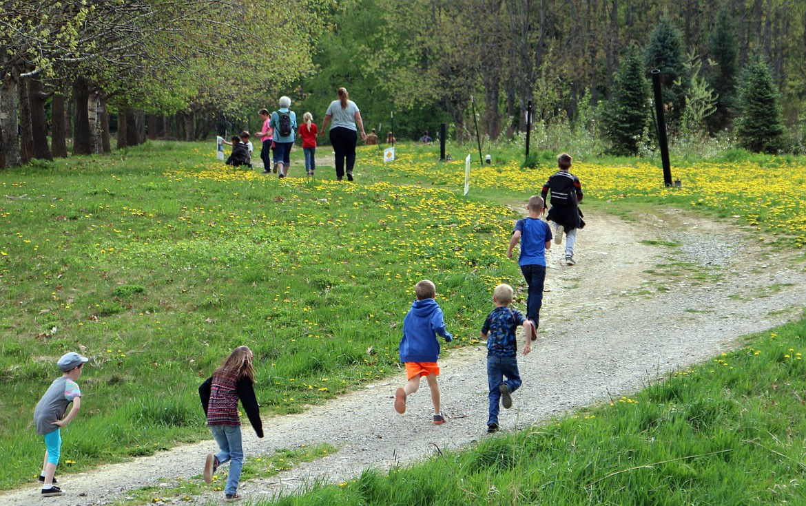 -- Photo by LYNNE HALEY

Children race to the first station on the University of Idaho's Story Walk trail.