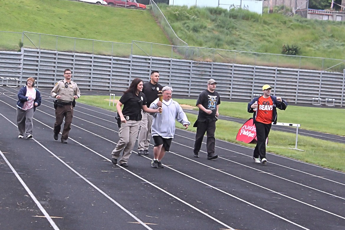 &#151;Photo courtesy JOSEPH ZAHNLE PHOTOGRAPHY
A contestant jogs to light the Olympic Torch as Idaho Department of Corrections officers run alongside as teams take part in the opening ceremony&#146;s parade held recently in Lewiston.