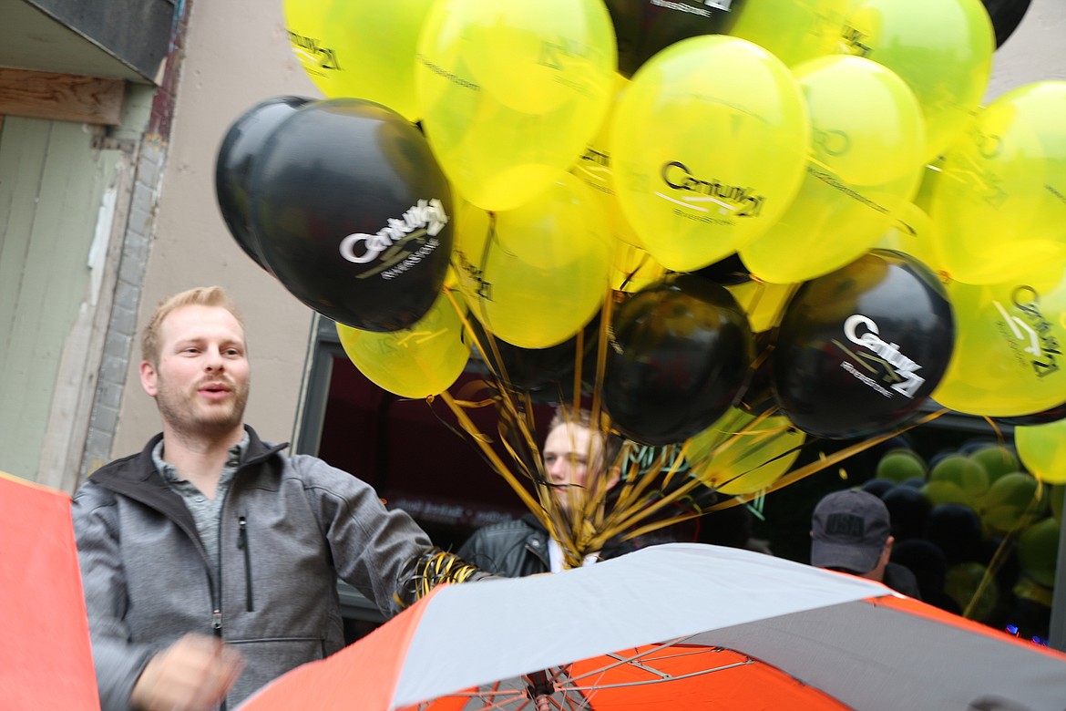 &#151;Photo by CAROLINE LOBSINGER
Ryan Welsh of Century 21 Riverstone hands balloons to young parade-goers during Friday&#146;s Lost in the &#145;50s parade.