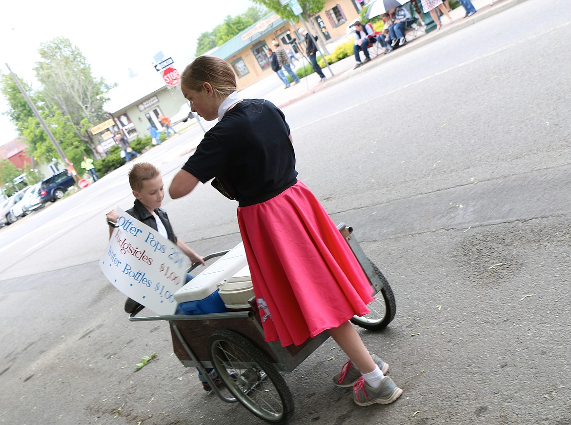 &#151;Photo by CAROLINE LOBSINGER
Elizabeth and Jason Loutzenhiser sell frozen treats during Friday&#146;s Lost in the &#145;50s parade.