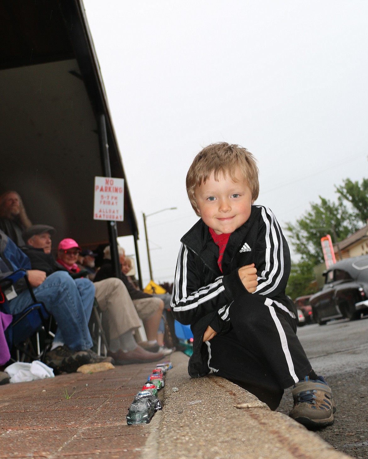 &#151;Photo by CAROLINE LOBSINGERA young fan displays his own classic cars while watching the Lost in the &#145;50s parade on First Avenue on Friday.