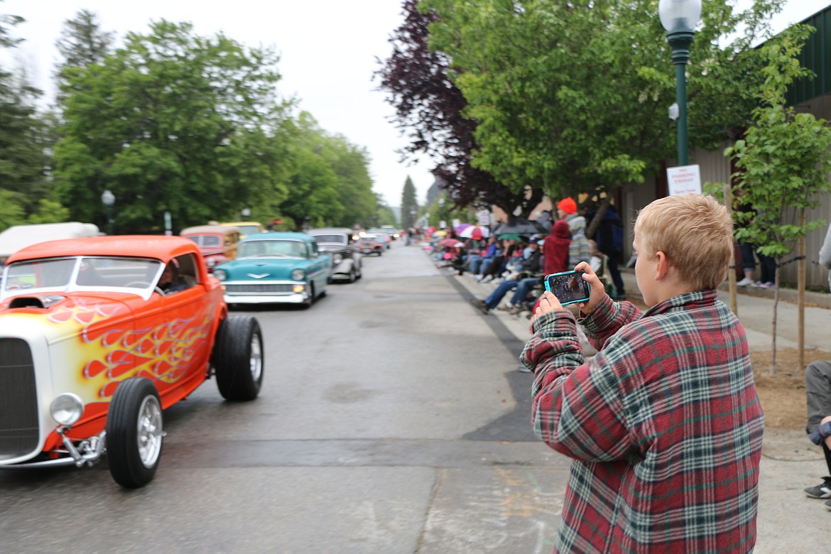 &#151;Photo by CAROLINE LOBSINGERA young photographer takes a picture of cars driving down Church Street during Friday&#146;s Lost in the &#145;50s parade.