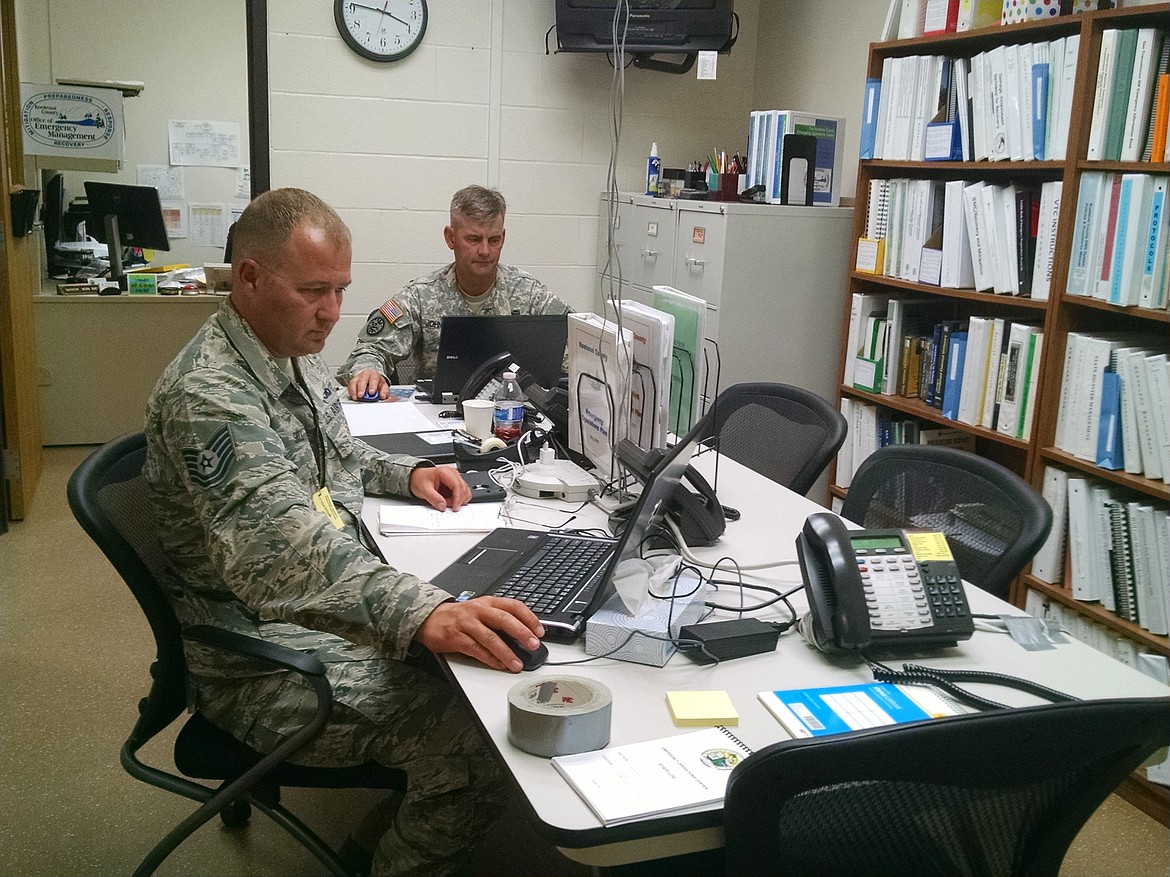 Michael Shroll, left, and Dan Johnson, both of the Idaho Army National Guard, assist in the emergency operations center on Wednesday at the Kootenai County Sheriff&#146;s Office. 
BRIAN WALKER/Hagadone 
News Network