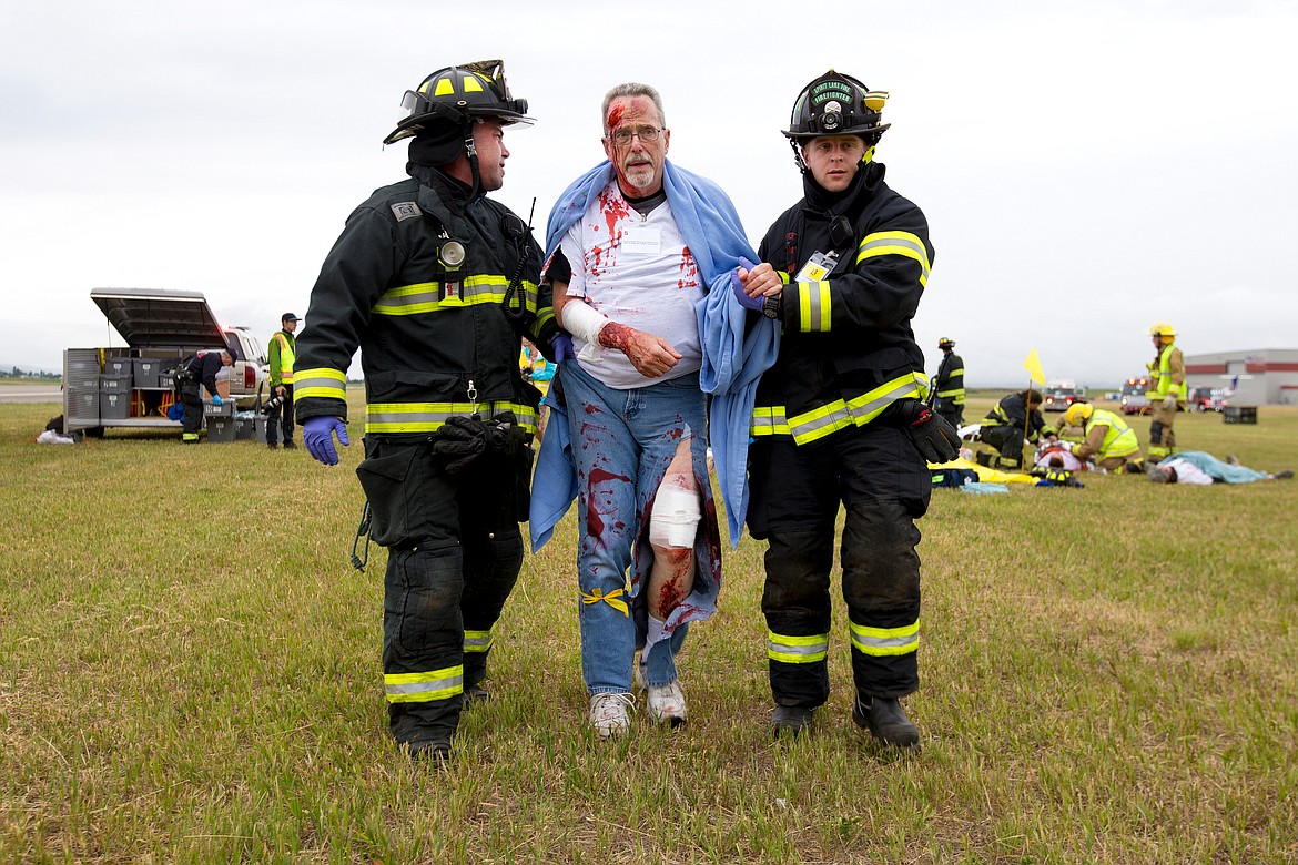 JAKE PARRISH/Press

Spirit Lake firefighters Jason Kelly, left, and Conner Peery help a crash &#147;victim&#148; on Friday during a plane crash training exercise at the Coeur d&#146;Alene Airport.