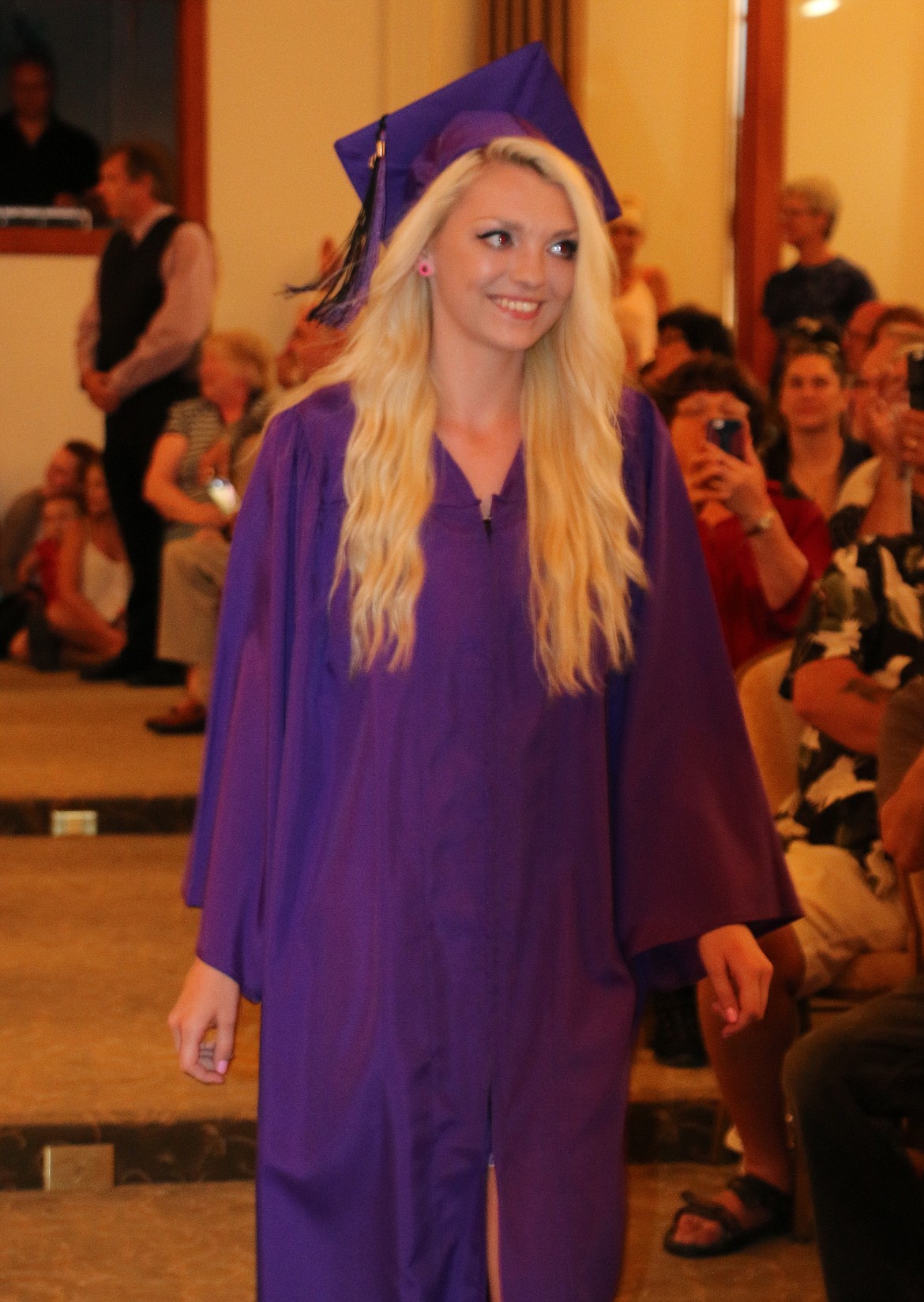 -- Photo by LYNNE HALEY

Danae Christy walks past family and friends at the beginning of graduation night.