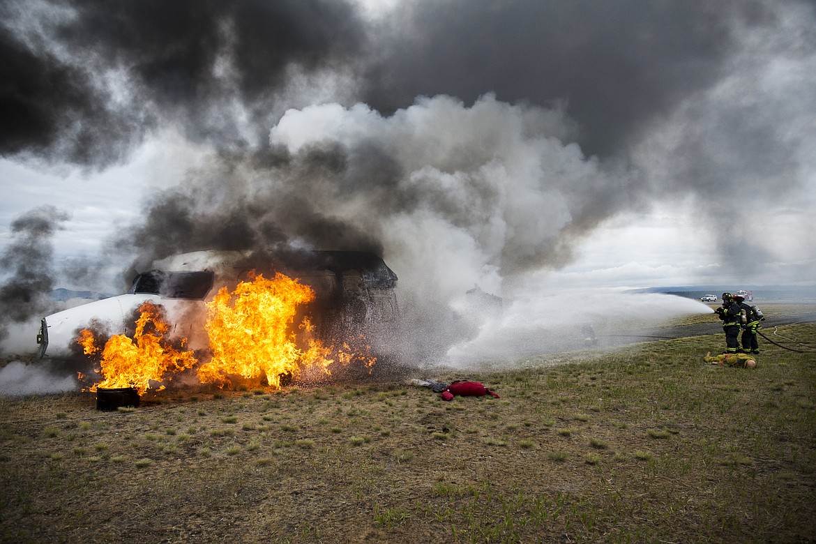 LOREN BENOIT/Press

Northern Lakes firefighters Caleb Tyler and Capt. Scott Hochberger spray the front-half of a plane during a two-plane crash exercise at the Coeur d'Alene Airport on Friday.