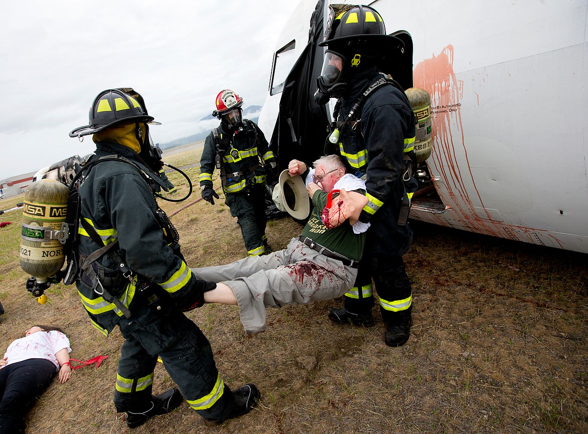 JAKE PARRISH/PressNorthern Lakes firefighters carry out a crash victim during a plane crash training exercise on Friday at the Coeur d'Alene Airport.