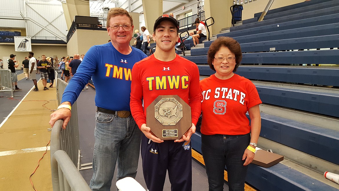 Courtesy photo
Former Badger wrestler Adam Hall displays his trophy after winning the University Men&#146;s Freestyle Championship. He is joined in the picture by his parents, Roland and Linda Hall.