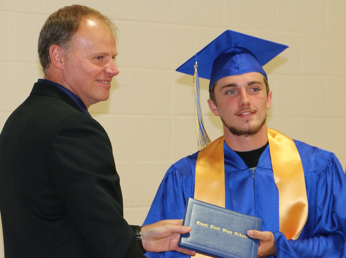 -- Photo by LYNNE HALEY

Clark Fork Junior/Senior High School principal Phil Kemink hands Garrett Pomerleau his diploma.