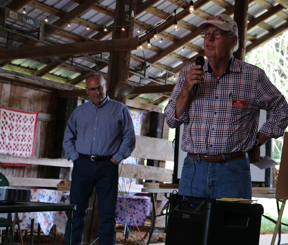 -- Photo by LYNNE HALEY

Tom Albertson, left, listens as Don Pischner of the Idaho Historical Society speaks at a celebration marking the ranch's 100th year.