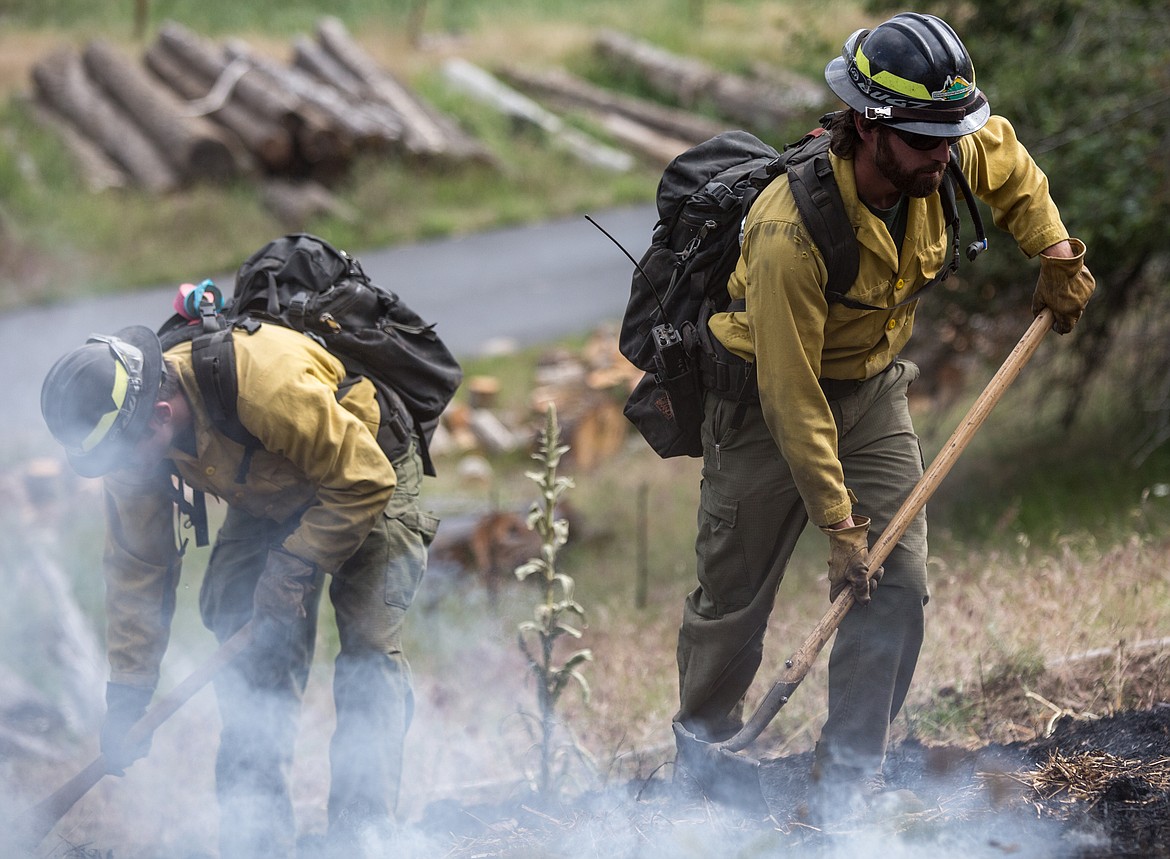 KATIE HARTWIG/Hagadone News Network
Idaho Department of Lands firefighters Trevor Livingston, left, and Travis Hixon work together to contain a controlled fire during a demonstration on Thursday.