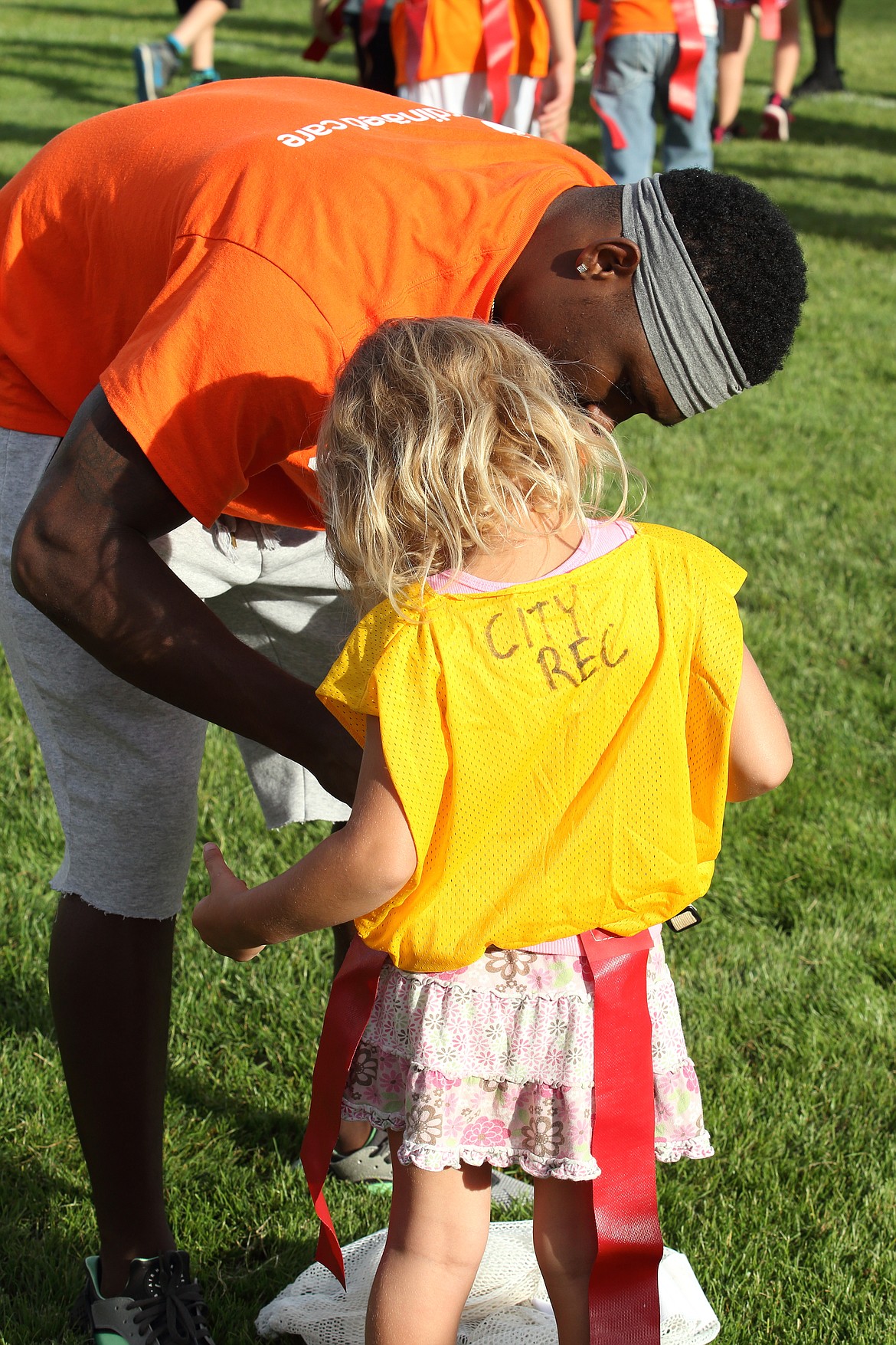 &#151;Photo by JIM McKIERNAN
Empire player Adrian James helps Katie Garrison, of Sandpoint with her flag football belt. James is a defensive back.