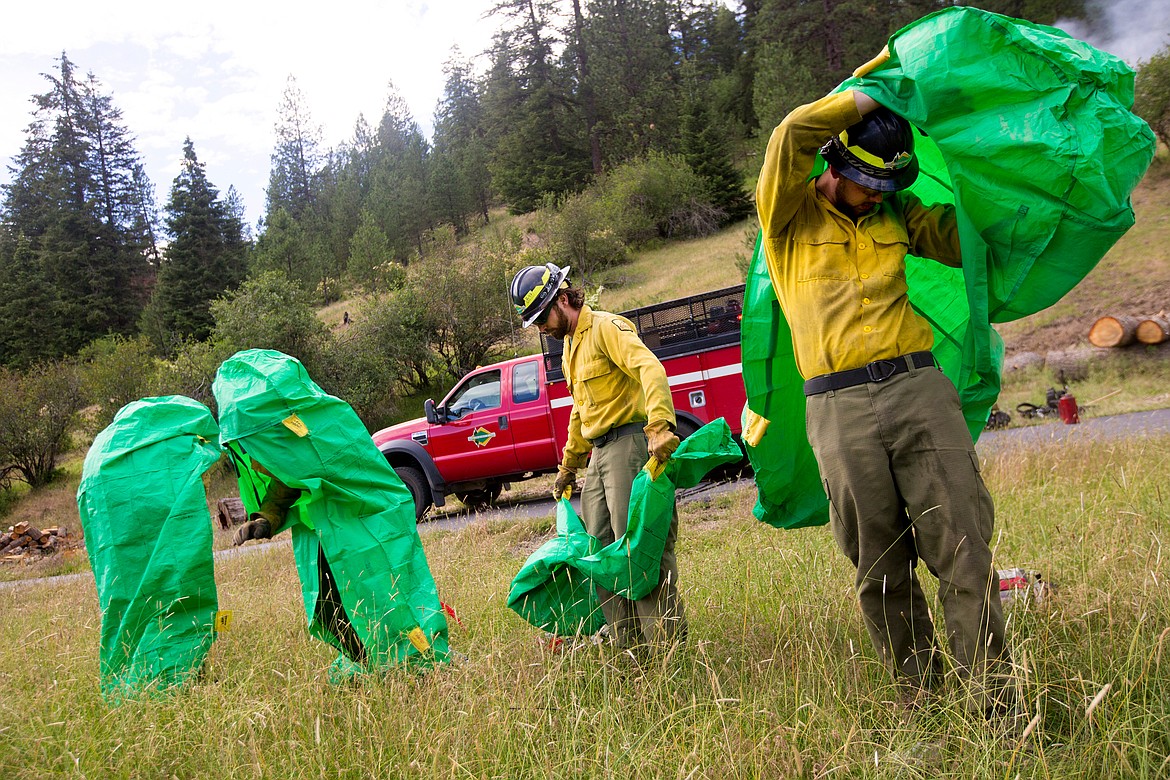 JAKE PARRISH/PressFirefighters from the Idaho Department of Lands deploy emergency fire shelters during a demonstration on Thursday at the Funk Family Tree Farm in Wolf Lodge.