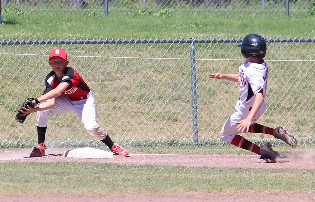 &#151;Photo by ANNA BUTLER
Zeke Roop catches the ball and applies the tag for the final out of the game, propelling the Sandpoint Majors to the district championship against Lewiston starting today, and the right to advance to Boise for the state championship. &#147;This is the play that makes one team scream with joy and the other want to cry in defeat,&#148; said assistant coach Tony Butler, whose team nearly blew a six run lead. &#147;Heart attack for coaches averted successfully.&#148; Augie Lehman faced 21 batters and struck out four with zero walks, Collin Roos had two hits and three RBIs and the team has been playing strong defense and running the bases aggressively. &#147;Once we get a runner on base we have some kids who can flat out run and will make the defense pay for any slight hesitation,&#148; said Butler.