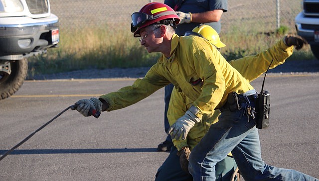 -Photo by JUDD WILSON
Rick Bonser practices deploying a wildland fire hose June 28 at the West Pend Oreille Fire District.