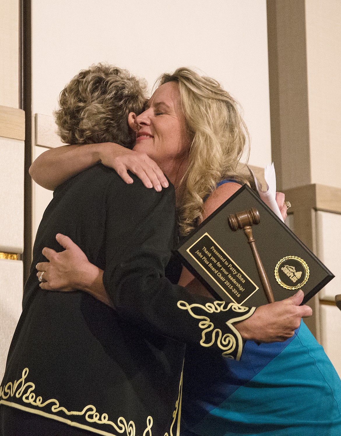 LOREN BENOIT/PressIncoming Jobs Plus Board Chair, Eve Knudtsen, right, hugs Patty Shea after handing her an award plaque thanking Shea for her leadership.