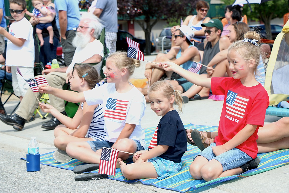 &#151;Photo by CAROLINE LOBSINGER
Young parade watchers wave their flags as they watch floats go by in the Sandpoint Lions&#146;Grand Parade on Monday.