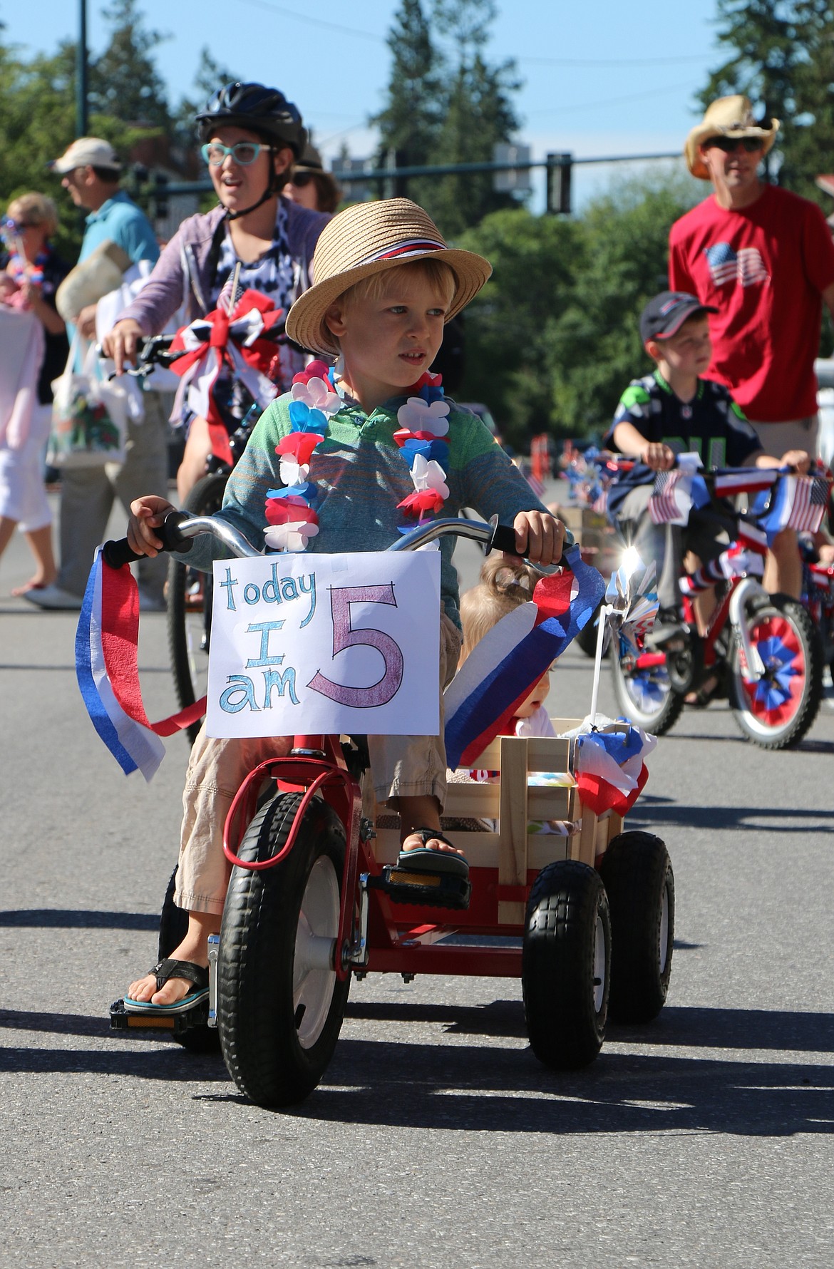 &#151;Photo by CAROLINE LOBSINGER
A youngster celebrates his fifth birthday by riding in the Sandpoint Lions Fourth of July Kids Parade on Monday.