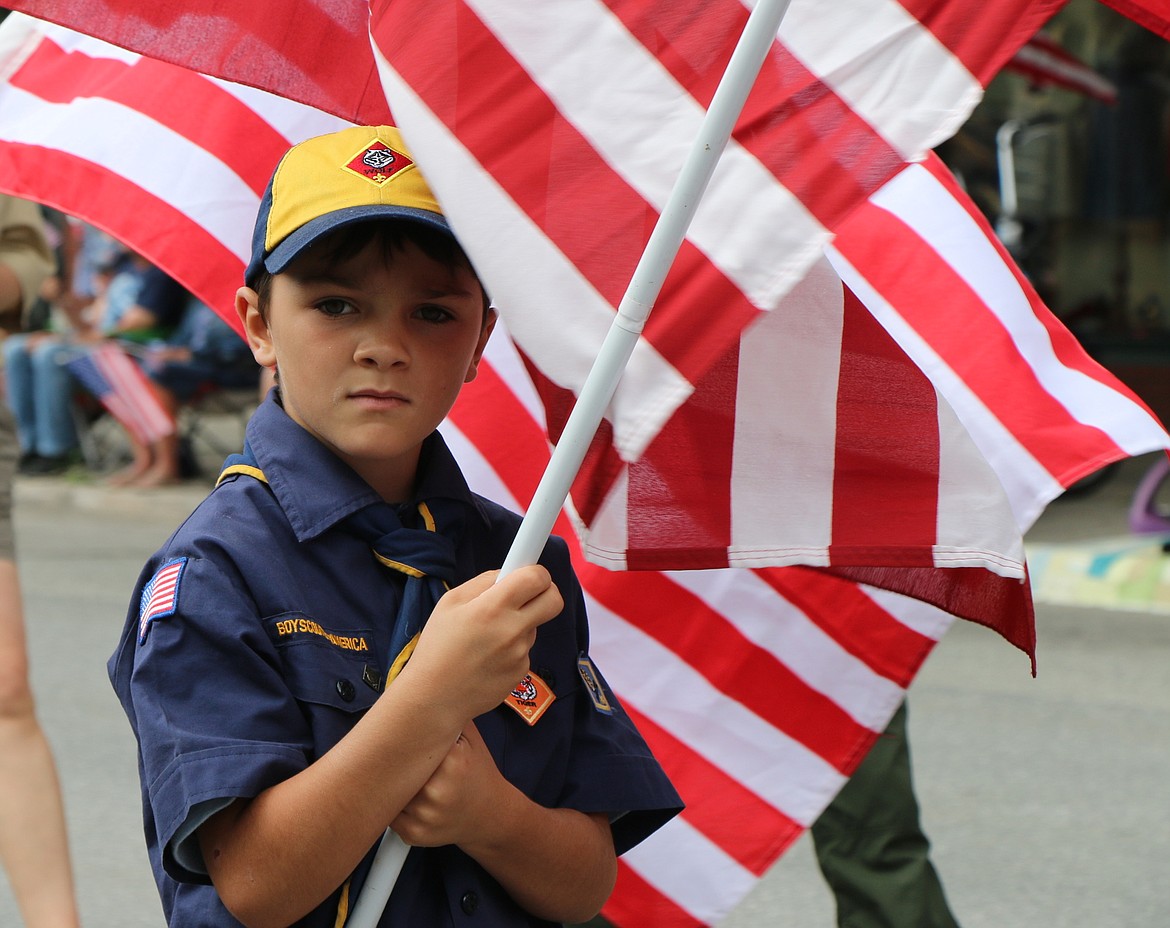 &#151;Photo by CAROLINE LOBSINGER
A young Scout marches with his troop during Monday's Grand Parade as thousands of people packed downtown Sandpoint to take part in the annual event.