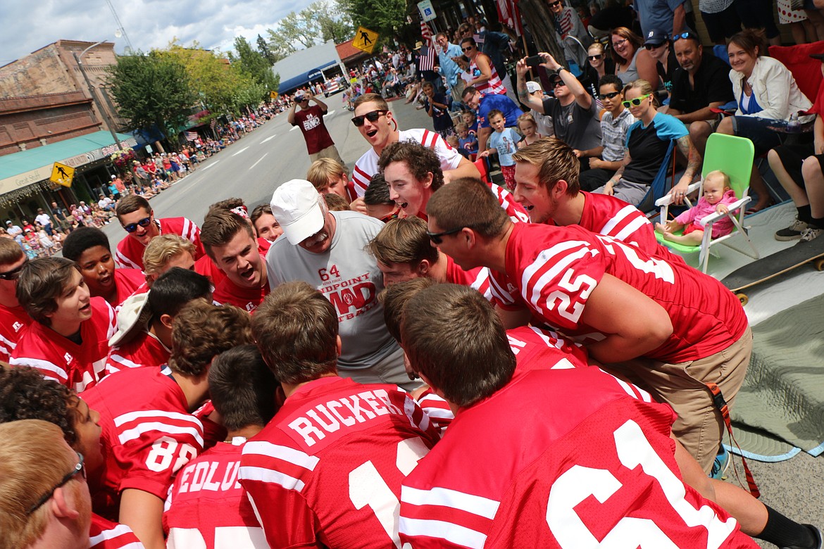 &#151;Photo by CAROLINE LOBSINGER
Sandpoint High School football players pull Ray Miller, one of the Bulldogs' assistant coaches, out of the crowd lining First Avenue to chant, &quot;defense, defense, defense&quot; before continuing on their way. The group was just one of about 100 taking part in the Sandpoint Lions' Grand Parade on the Fourth of July Monday.