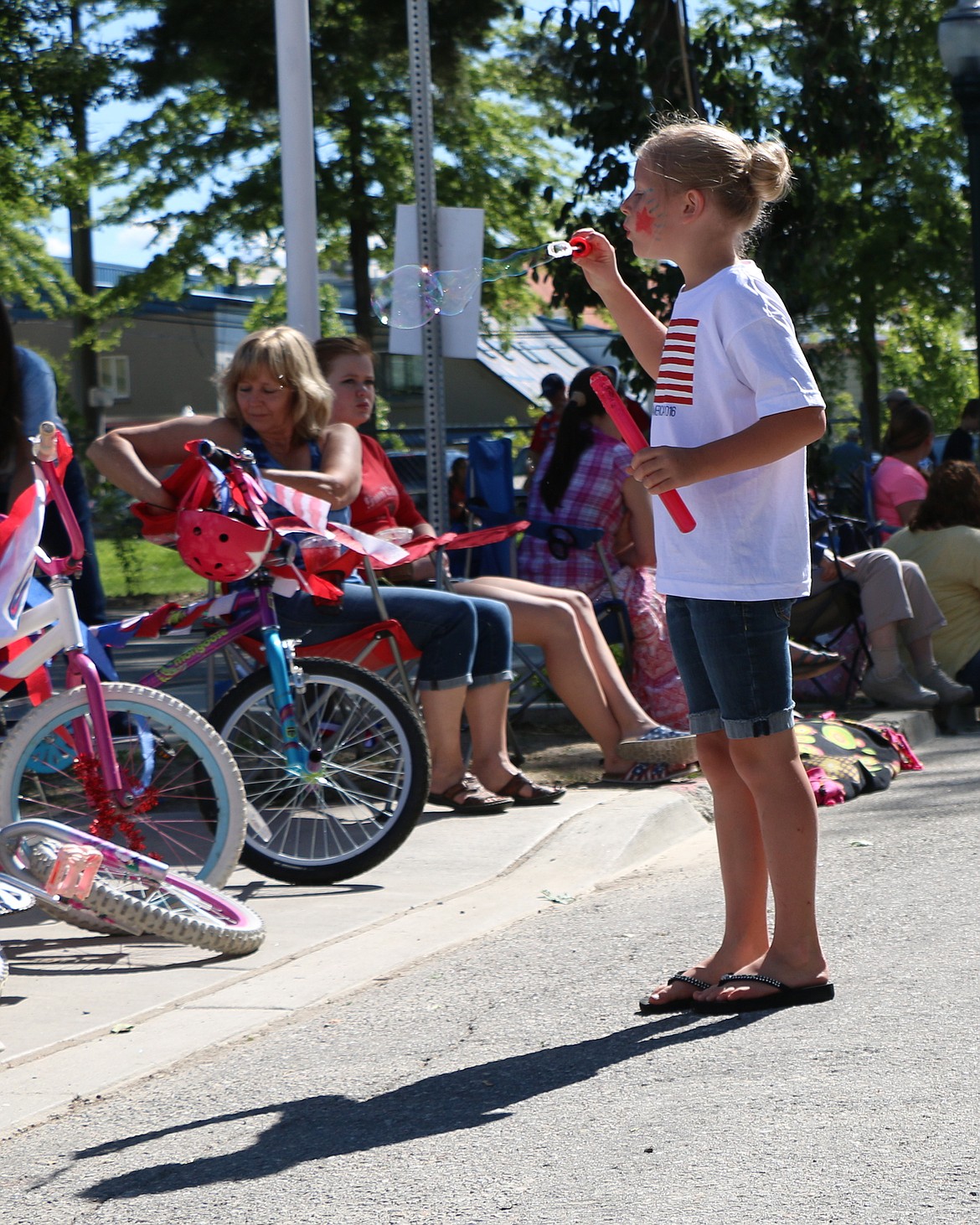 &#151;Photo by CAROLINE LOBSINGER
A youngster concentrates as she blows bubbles while waiting for the start of the Sandpoint Lions&#146; Grand Parade on Monday.