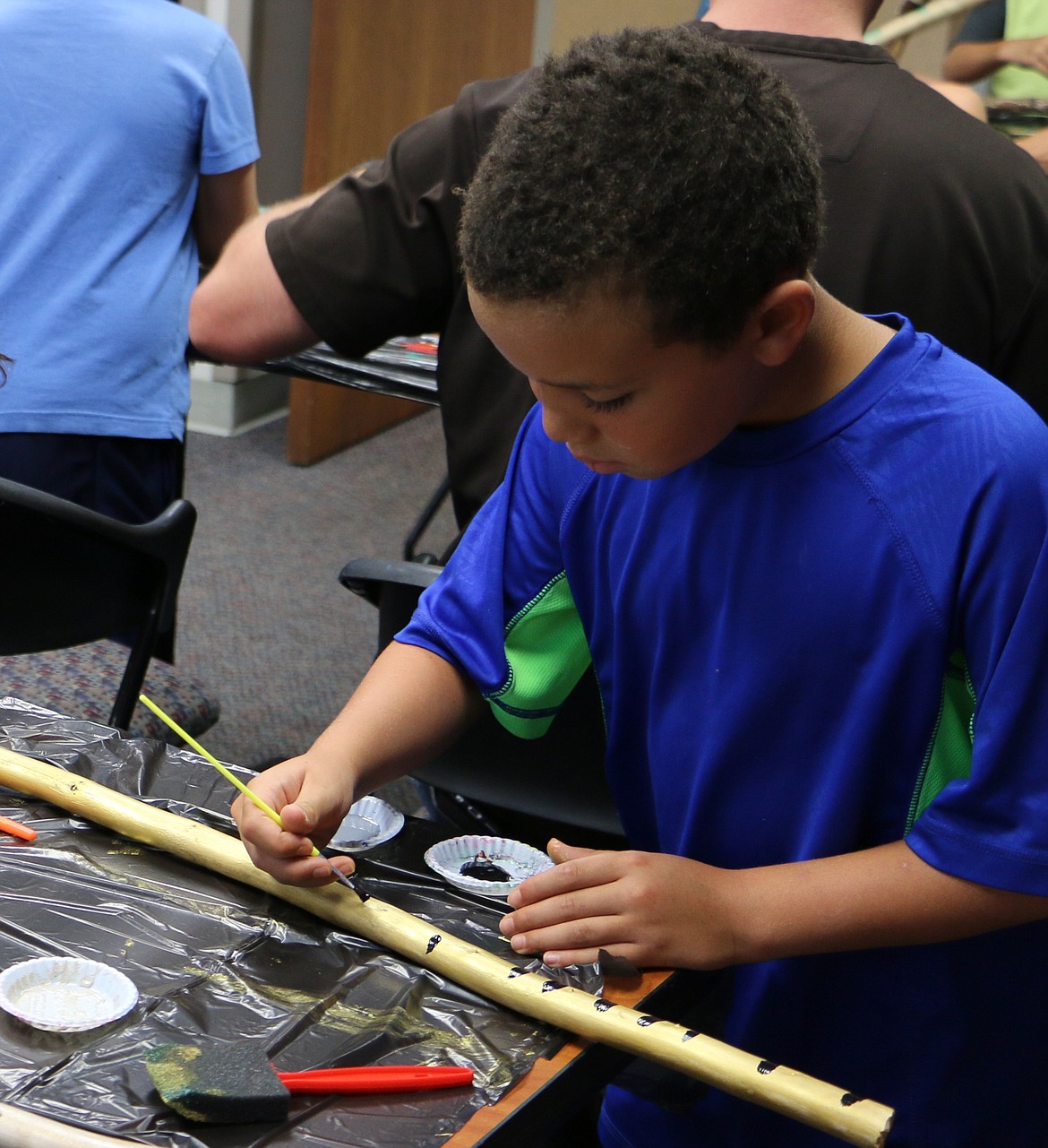 &#151;Photo by LYNNE HALEY
Ashlei Hawkins focuses his artistic talent on a walking stick at the Sandpoint branch EBCLD Make It At the Library event Wednesday.