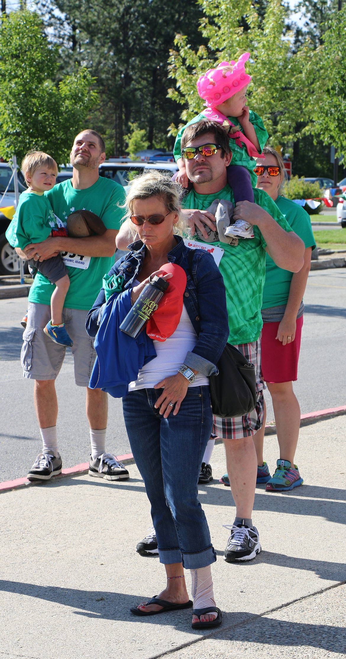 &#151;Photo by CAROLINE LOBSINGER
Ayria Harrison, 3, sits atop her dad's shoulders as they wait for the start of Jacey's Race on Sunday. One of four beneficiaries, the toddler took part in the race with her family and several hundred community residents.