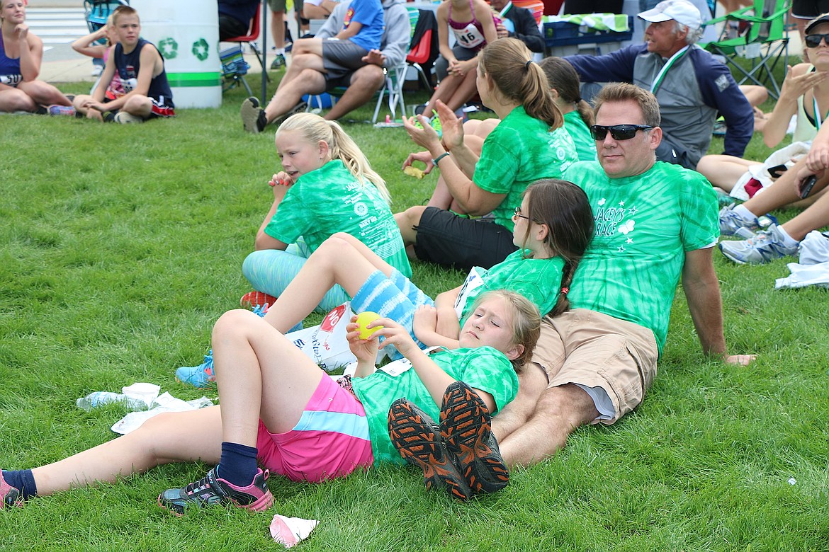 &#151;Photo by CAROLINE LOBSINGER
A family kicks back in the grass while they watch the awards ceremony after the end of Jacey's Race on Sunday.