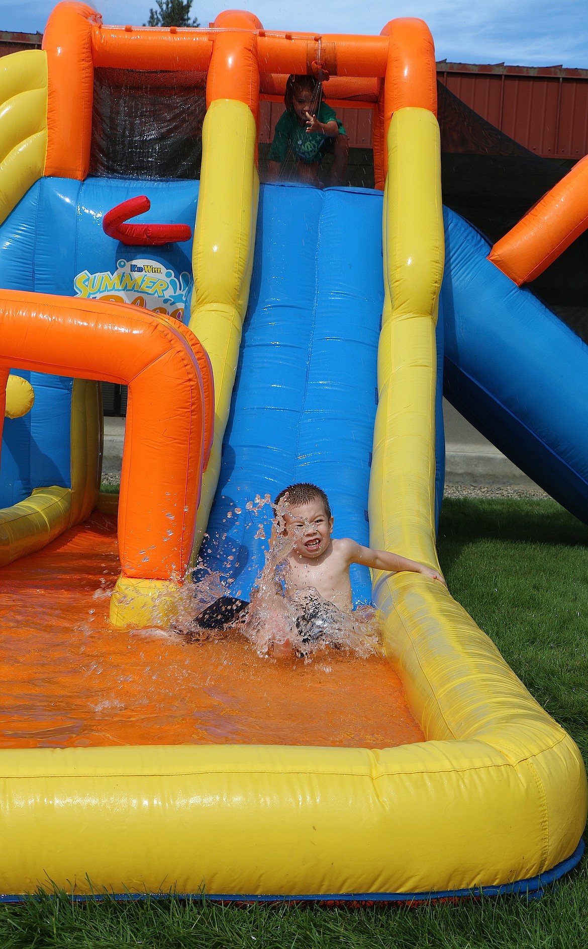 &#151;Photo by CAROLINE LOBSINGER
A youngster splashes into the water at the end of a water slide at the Jacey&#146;s Race expo area.