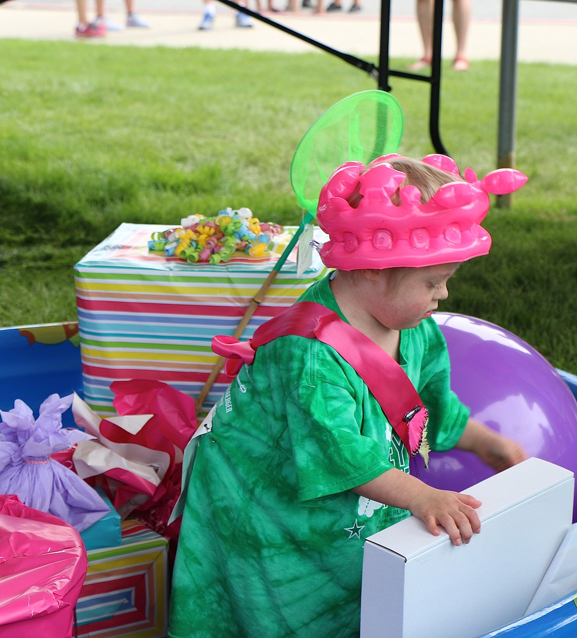 &#151;Photo by CAROLINE LOBSINGER
Ayria Harrison, 3, who is battling acute lymphocytic leukemia, opens a present at the end of Jacey&#146;s Race. One of four beneficiaries, the toddler took part in the race with her family and several hundred community residents.