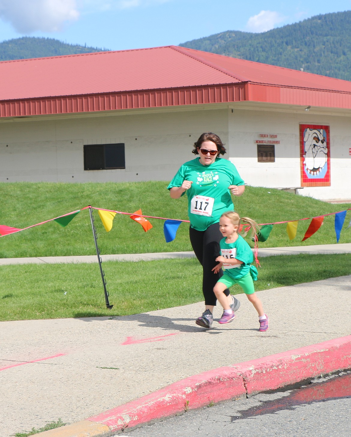 &#151;Photo by CAROLINE LOBSINGER
A younster and her mother race toward the finish line at the end of the 1K Jacey's Race event.